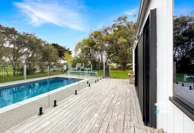 Discover a modern retreat featuring a spacious deck and inviting pool surrounded by lush greenery.