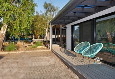 Discover this contemporary home featuring inviting outdoor seating and a spacious yard, perfect for entertaining.