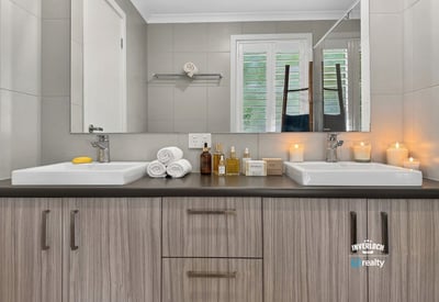 Modern bathroom featuring dual sinks, ample storage, and welcoming natural light for a refreshing atmosphere.
