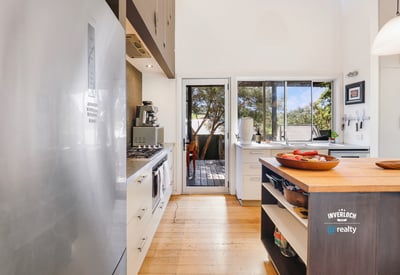 Bright kitchen featuring modern appliances and seamless access to a deck, perfect for entertaining.