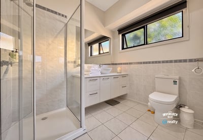 Bright, modern bathroom featuring a spacious shower, sleek cabinetry, and ample natural light for daily comfort.