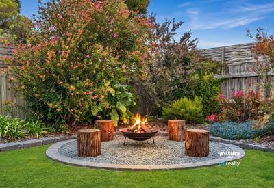 Discover a cozy outdoor oasis featuring a fire pit surrounded by lush landscaping and vibrant flowers.