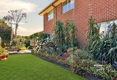 Well-maintained backyard surrounded by vibrant landscaping, perfect for outdoor gatherings or relaxing afternoons.