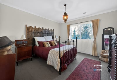 Cozy bedroom featuring unique decor, a wrought-iron bed frame, and ample natural light from the window.