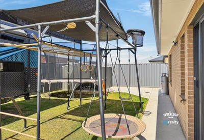This property features a spacious outdoor area, equipped with a unique play structure and ample lawn space.