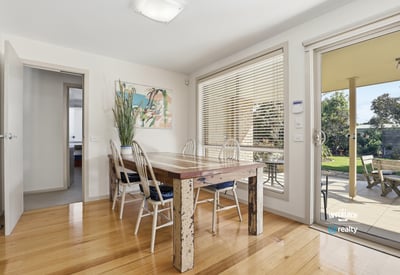 Bright dining area featuring large windows, a spacious table, and easy access to a private outdoor space.