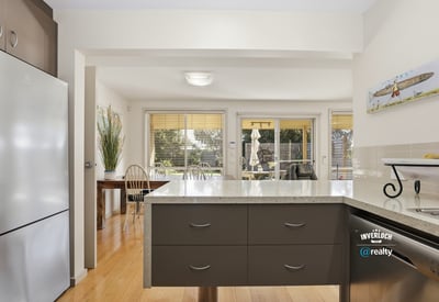 Bright kitchen with modern finishes, open to a sunlit dining area, ideal for entertaining.