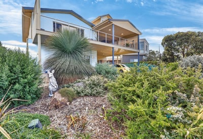 Modern home featuring a spacious design, lush landscaping, and panoramic views in a desirable neighborhood.