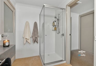 Bright and modern bathroom featuring a spacious walk-in shower and convenient storage options.