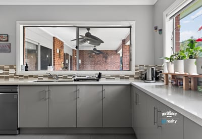 Bright kitchen with modern finishes and a large window overlooking the outdoor living area.