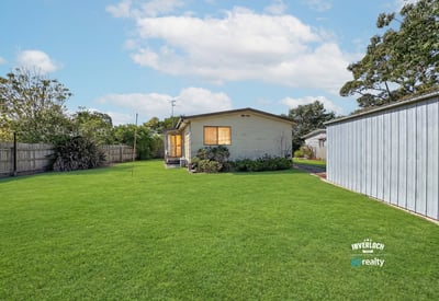 Spacious backyard retreat featuring a well-maintained home, perfect for outdoor activities and family gatherings.