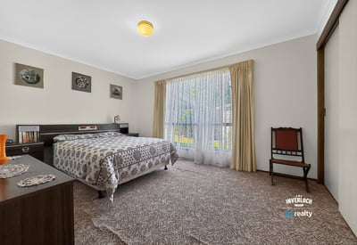 Spacious bedroom featuring large windows that invite natural light and offer a view of the garden.