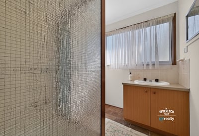 Bright bathroom featuring a spacious layout, large window for natural light, and practical design elements.