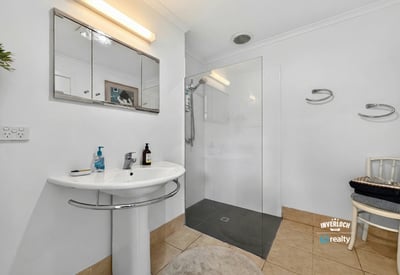 Modern bathroom featuring a glass shower, sleek fixtures, and ample natural light for a bright atmosphere.
