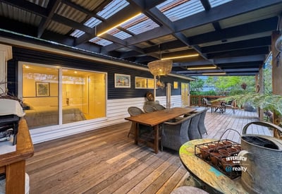 Spacious outdoor deck with ample seating, perfect for relaxed gatherings and enjoying the surrounding greenery.