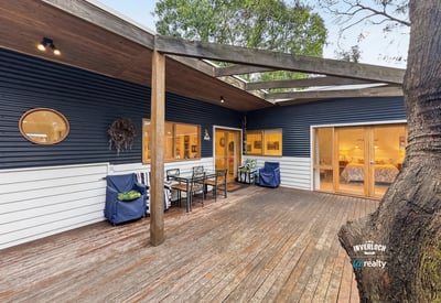 Contemporary home featuring a spacious outdoor deck, perfect for entertaining in a natural setting.