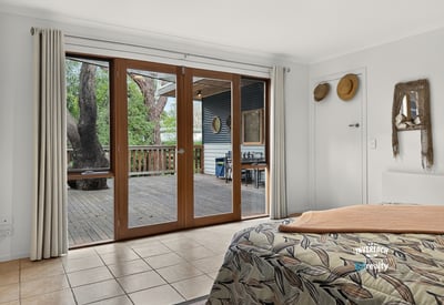 Bright and spacious bedroom with large sliding doors opening to a private outdoor deck area.