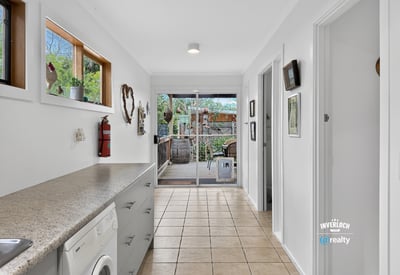 Spacious laundry area flows seamlessly into a bright outdoor patio perfect for entertaining and relaxation.