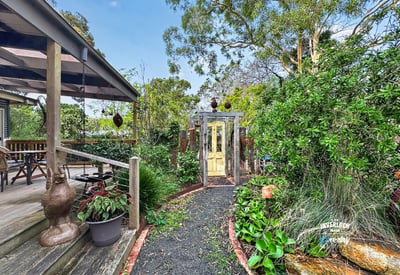 Discover a unique garden pathway leading to a beautifully landscaped outdoor space perfect for relaxation.