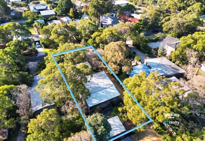 Spacious property surrounded by lush greenery, offering ample outdoor space and potential for development.