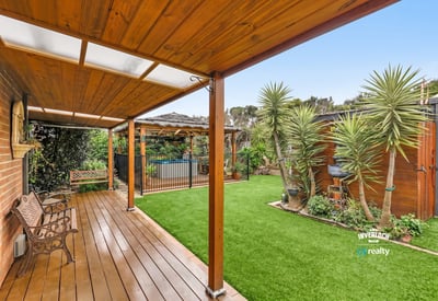Discover a spacious outdoor oasis featuring sleek decking, vibrant greenery, and a refreshing pool area.