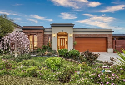 This inviting home features vibrant landscaping, a spacious garage, and a welcoming entryway.