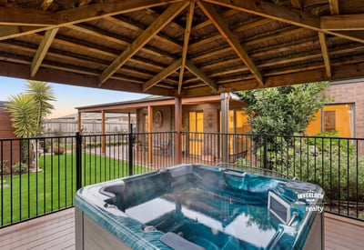 Relax in the inviting hot tub surrounded by lush landscaping and a spacious outdoor retreat.