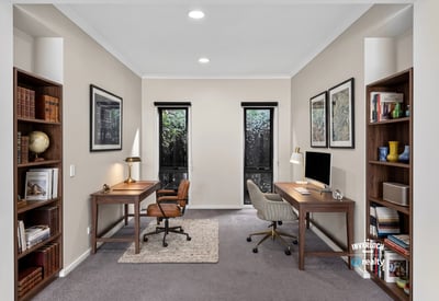 Spacious dual office setup featuring natural light, modern furnishings, and ample shelving for productivity.