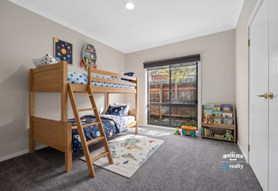 Bright, inviting kids' bedroom featuring a lofted bed and spacious play area with natural light.