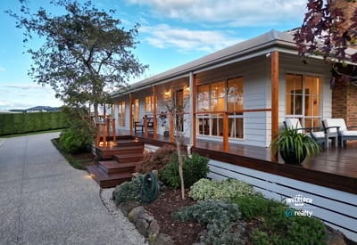 This inviting home features a spacious porch, landscaped gardens, and ample natural light throughout.