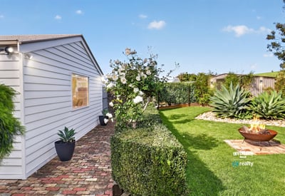 Discover a well-maintained outdoor space featuring lush greenery and a cozy fire pit for gatherings.