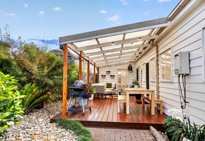 Spacious covered patio with ample seating and outdoor grilling area, perfect for entertaining and relaxing.