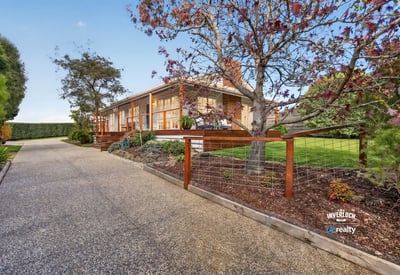 This welcoming home features spacious outdoor areas and a scenic driveway, perfect for family gatherings and relaxation.