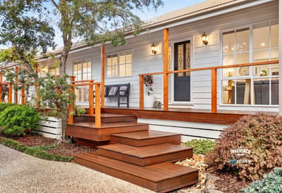 Experience modern living in this inviting home featuring a spacious deck, lush landscaping, and abundant natural light.