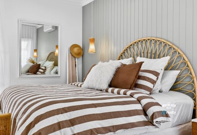 Cozy bedroom featuring a unique headboard, striped bedding, and modern accents for a relaxed atmosphere.