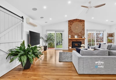 Bright, open living space featuring a distinctive brick fireplace and inviting natural light throughout.