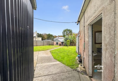 Spacious backyard with landscape potential, featuring accessible pathways and neighboring properties for a vibrant community feel.