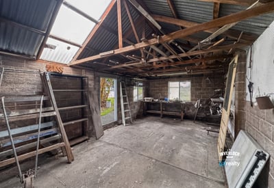 Spacious workshop with ample storage potential, featuring high ceilings and natural light for creative projects.