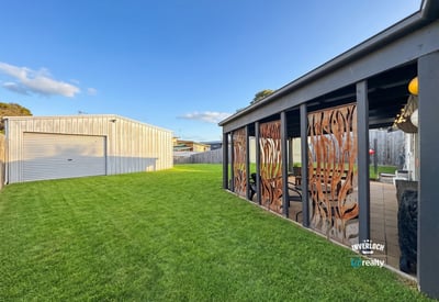 Spacious backyard featuring distinctive decor and a large garage, perfect for outdoor gatherings and hobbies.