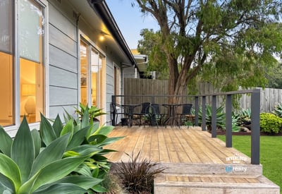 Discover a welcoming outdoor space featuring a spacious deck and lush greenery, perfect for relaxation.