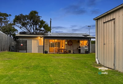 This inviting home features spacious green yard, modern amenities, and a cozy outdoor living area.