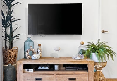 Modern living area featuring a sleek TV setup with tasteful decor and natural accents.