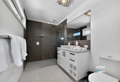 Modern bathroom featuring sleek finishes, spacious layout, and abundant natural light, perfect for relaxation.