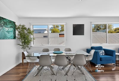 Bright dining area featuring large windows, modern furnishings, and an inviting atmosphere perfect for gatherings.