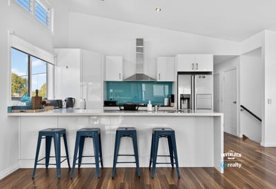 Modern kitchen featuring a striking turquoise backsplash, sleek cabinetry, and ample counter space for entertaining.
