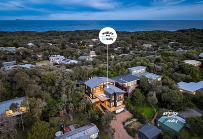 This coastal home offers breathtaking ocean views and modern architecture, nestled among lush greenery.