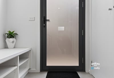 Modern entryway featuring a sleek door and minimalistic design, perfect for welcoming guests.