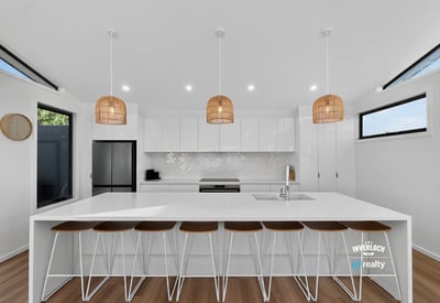 Bright and airy kitchen featuring modern finishes, ample counter space, and inviting seating for gatherings.