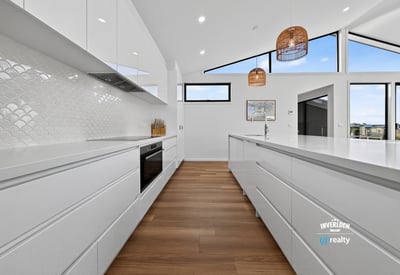 Bright and spacious kitchen featuring modern cabinetry, vast countertops, and stunning views through large windows.