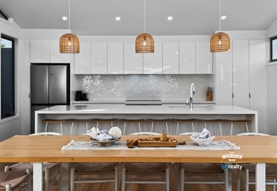 Modern open-plan kitchen featuring sleek cabinetry, a spacious dining area, and unique pendant lighting.